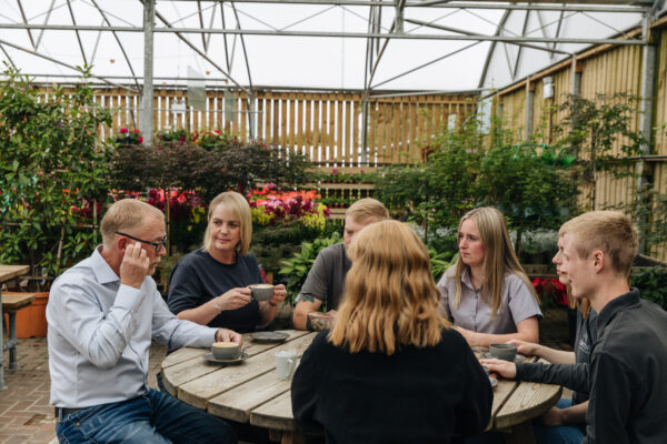Image shows the Smith's Team sat around a table in the garden centre